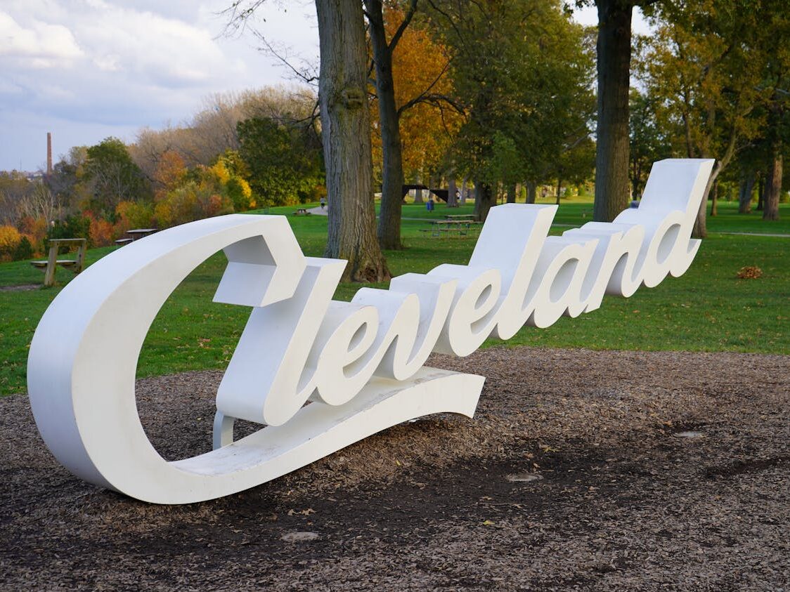 white cleveland script sign in a park