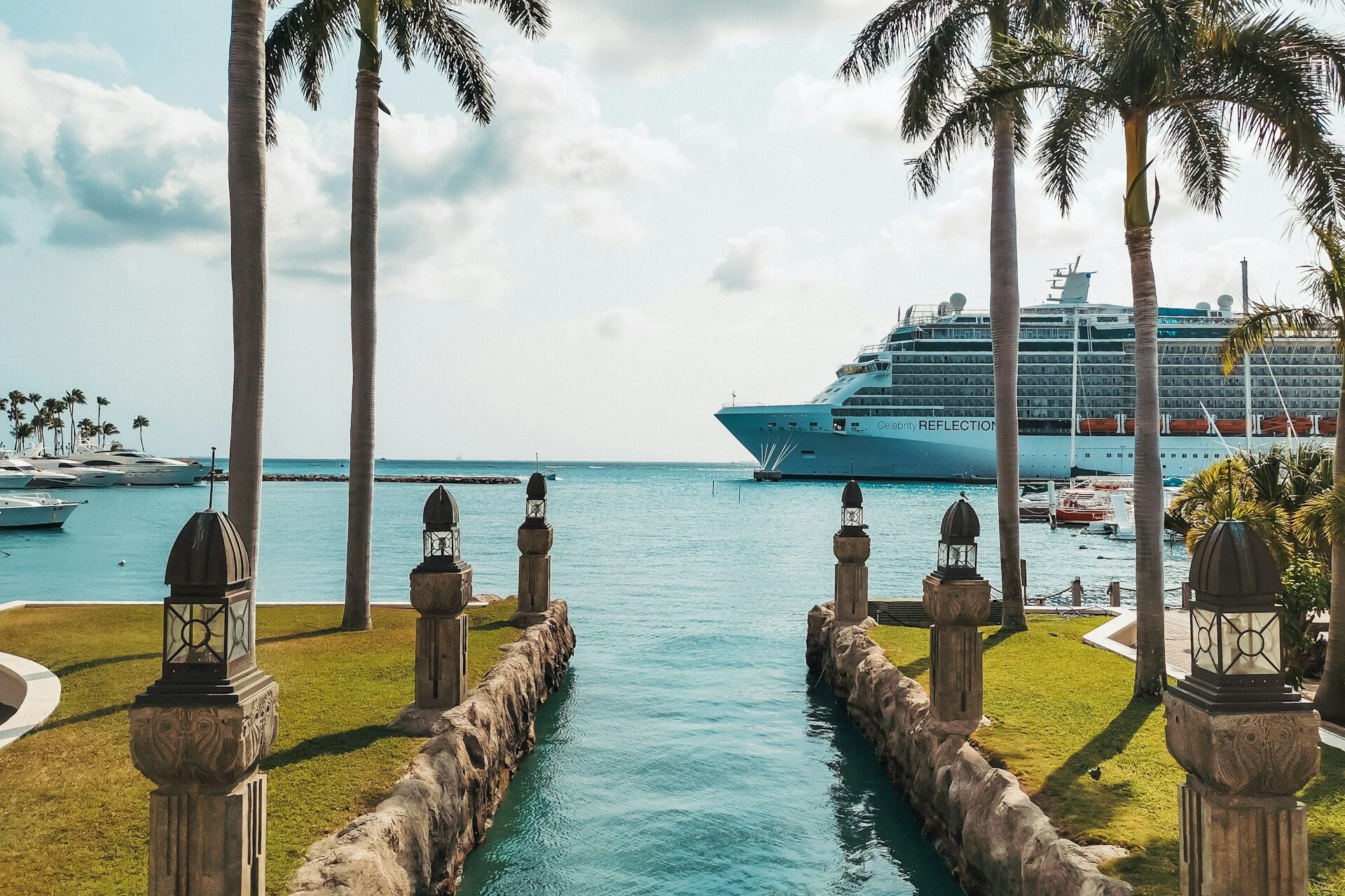 a cruise ship is in the water near palm trees