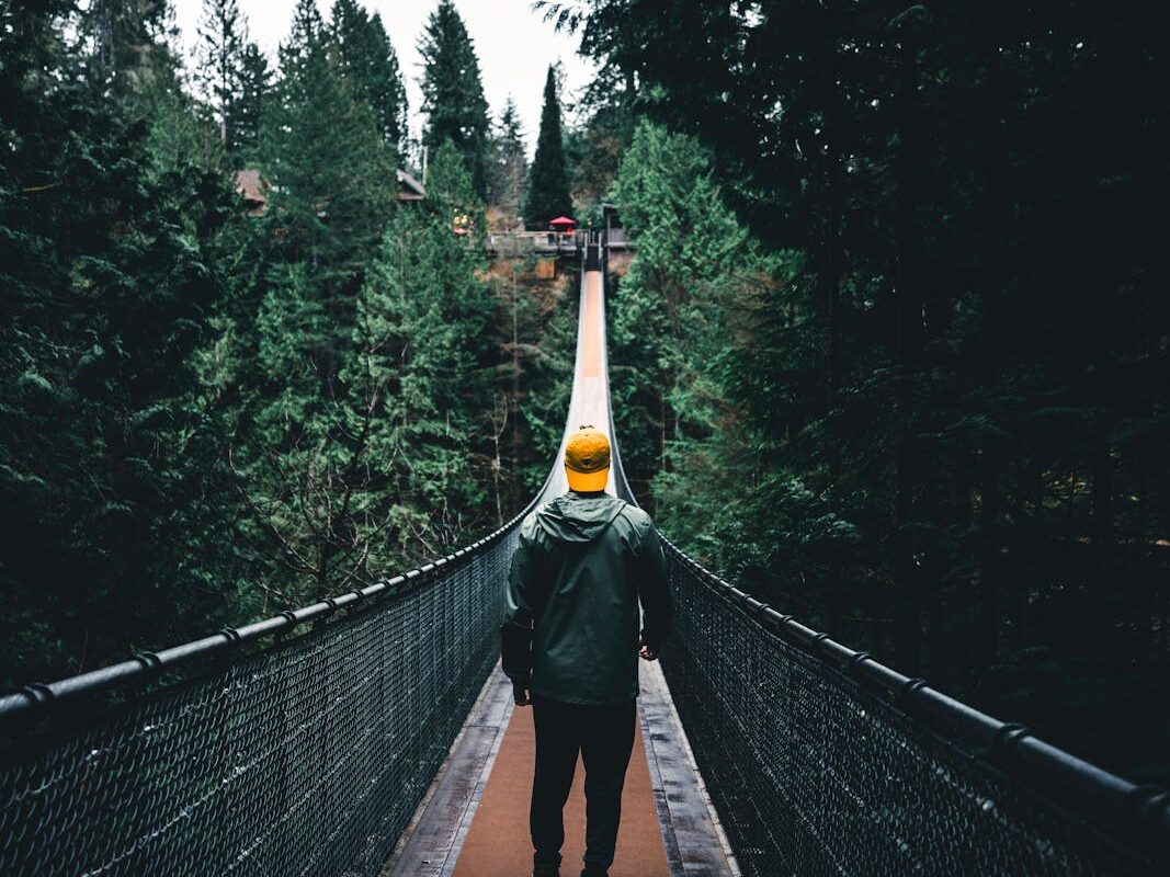 man walking on footbridge