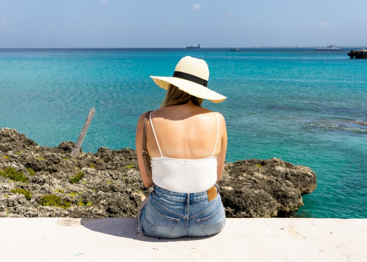 person sitting near body of water
