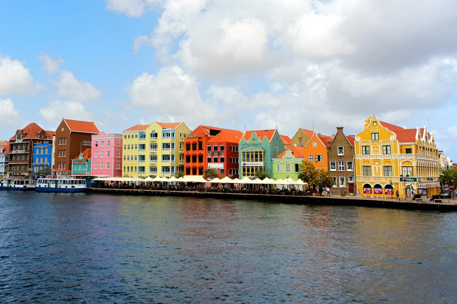 a row of colorful buildings on the side of a body of water